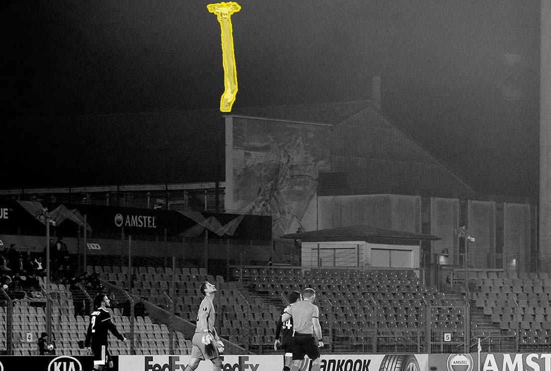 Dron s vlajkou připojenou k jeho podpalubí létajíce nad hlavami hráčů